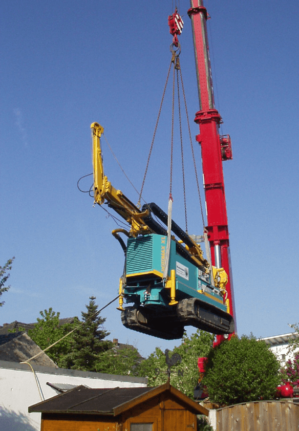 Bohrgerät wird per Kran auf die Baustelle gehoben